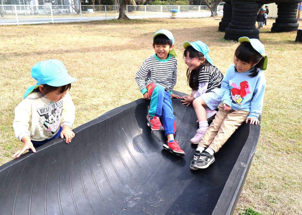 いつも同じ園庭で過ごしていたゾウ組さんキリン組さん♡
最後のお散歩はみんな大好き恐竜公園へ！



「一緒にすべろ～」
「みんな座ったら滑るよ～！」
友達と同じタイミングで滑る楽しさを味わうゾウ組さん！
さらに滑ったあとは、そのまま動かず太陽の光で温まったタイヤでひなたぼっこ♡