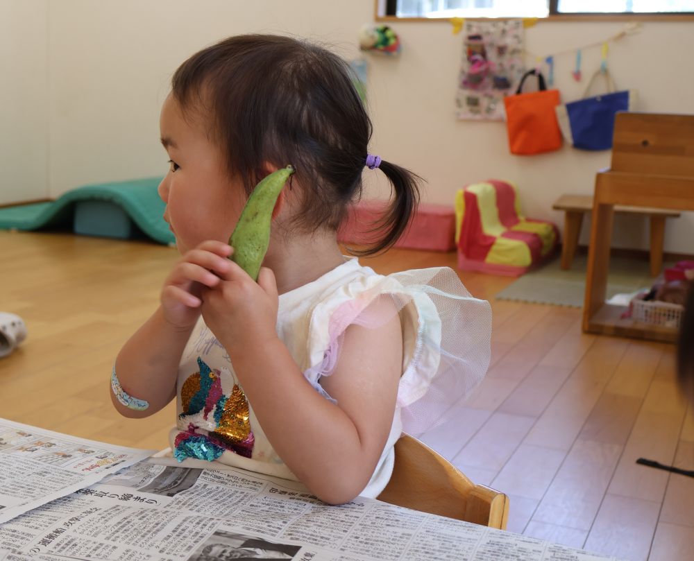 「なんか音がする・・・？」
耳に当てて音を聞いてみるSちゃん♪
剥き方を教わると、自分でやってみようとチャレンジしていました✨

全て剥き終わった後はみんなで給食室に届けにいきました😆
食育を通して様々な食べ物に興味を持っていって欲しいです♡