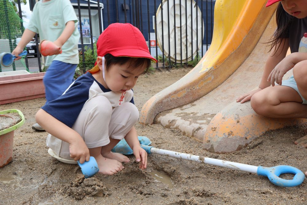 裸足で泥んこの感触を味わいながら遊びだしたSくん♡

こちらも友達の様子を見ながらコップを片手に何しようかな～・・・
と、思いを膨らませていました🤭

雨上がりもいろんな遊び方が楽しめて、ワクワクしながら梅雨も変えられそうなゾウ組さんでした！