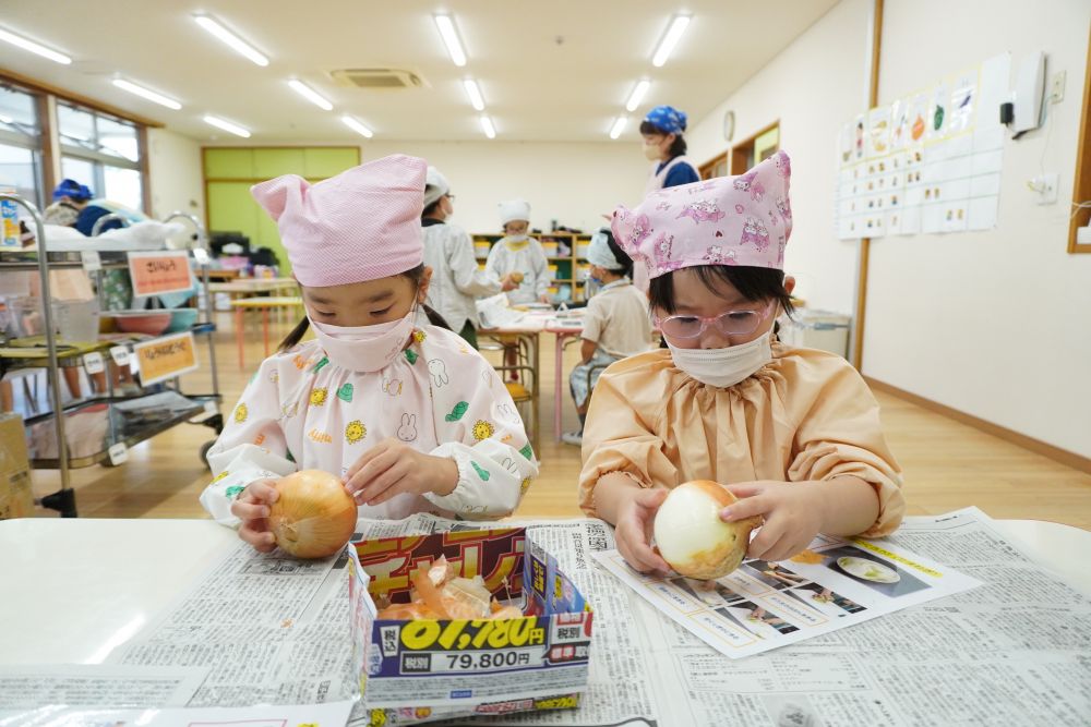 タマネギ担当のIちゃんとMちゃん！
白いところがいつでてくるかな？
一枚一枚丁寧にはがします♡