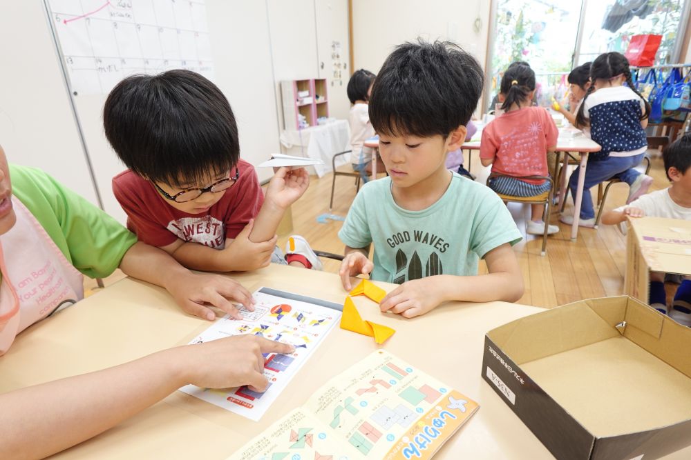 紙飛行機や手裏剣を折り紙で折ったり
投げたりして楽しんでいたキリン組♪
楽しかった遊びを小さい子達とやりたい！！
どうやって遊んでもらおうかな、、、、♡

まずは、
紙飛行機と手裏剣作り♪
「一番飛ぶのはこの折り方よね」
何回も作って飛ばしてきたみんな！！
どの折り方が飛ぶのか知っています♪
手裏剣を折るのはちょっと難しい、、
作り方を見たり、友達に聞いたりして
作っていきます♪