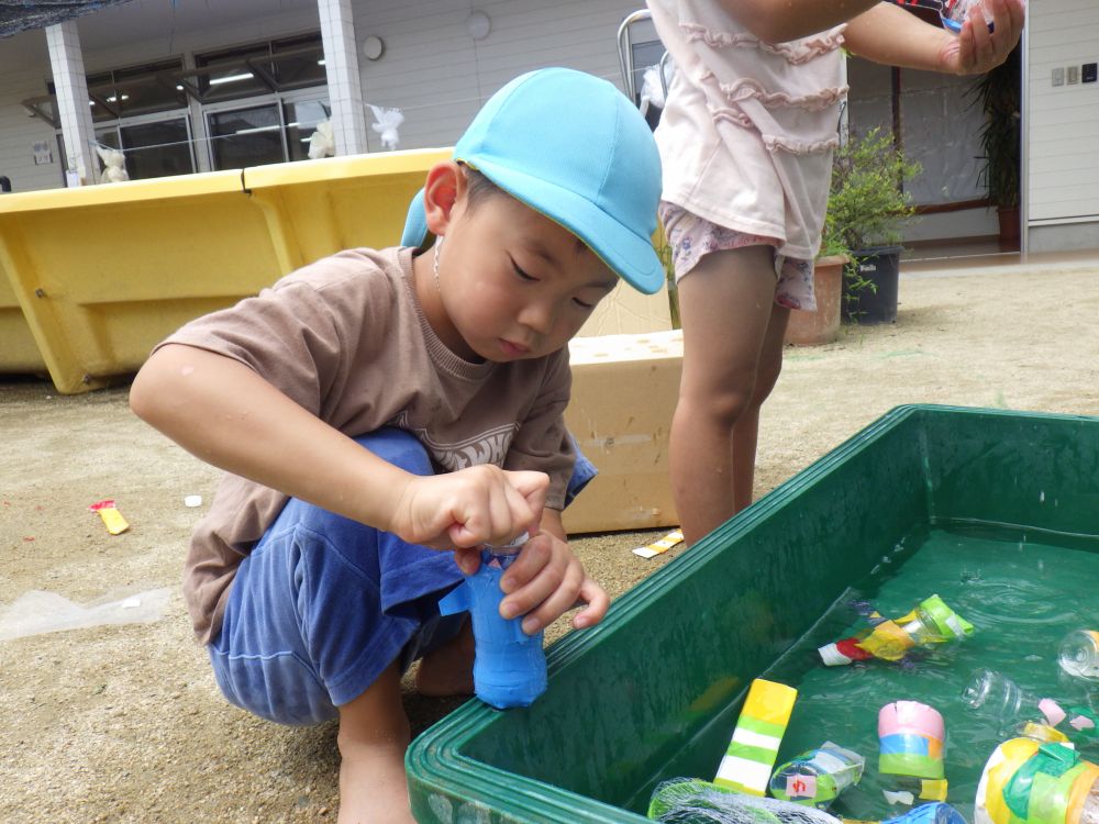 容器の中に水を入れて何してるのかな？
「水を入れたら、
　魚が沈むから魚すくいするの
　面白くなるかも！！」と
もっと楽しくなるように考えて
工夫していました！！
