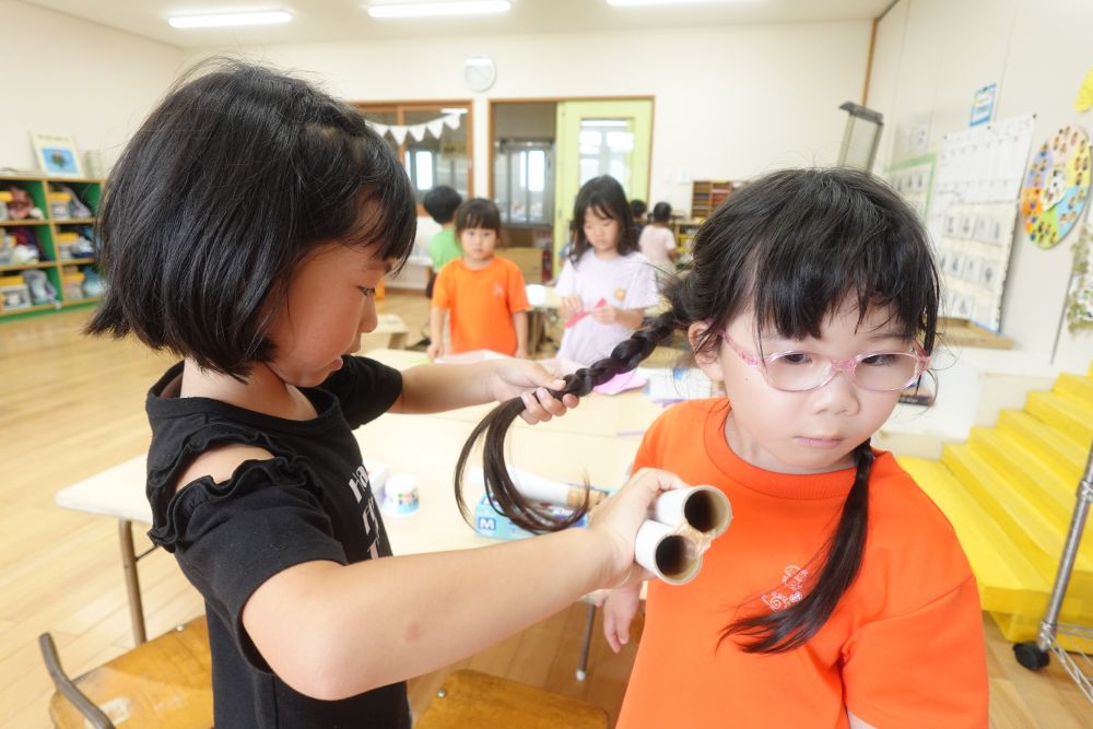「髪巻いてあげる～♪
　ママがこうしてるの
　見たことあるんよ！！」
ヘアアイロンをラップの芯で作って
友達の髪をクルクルに♡