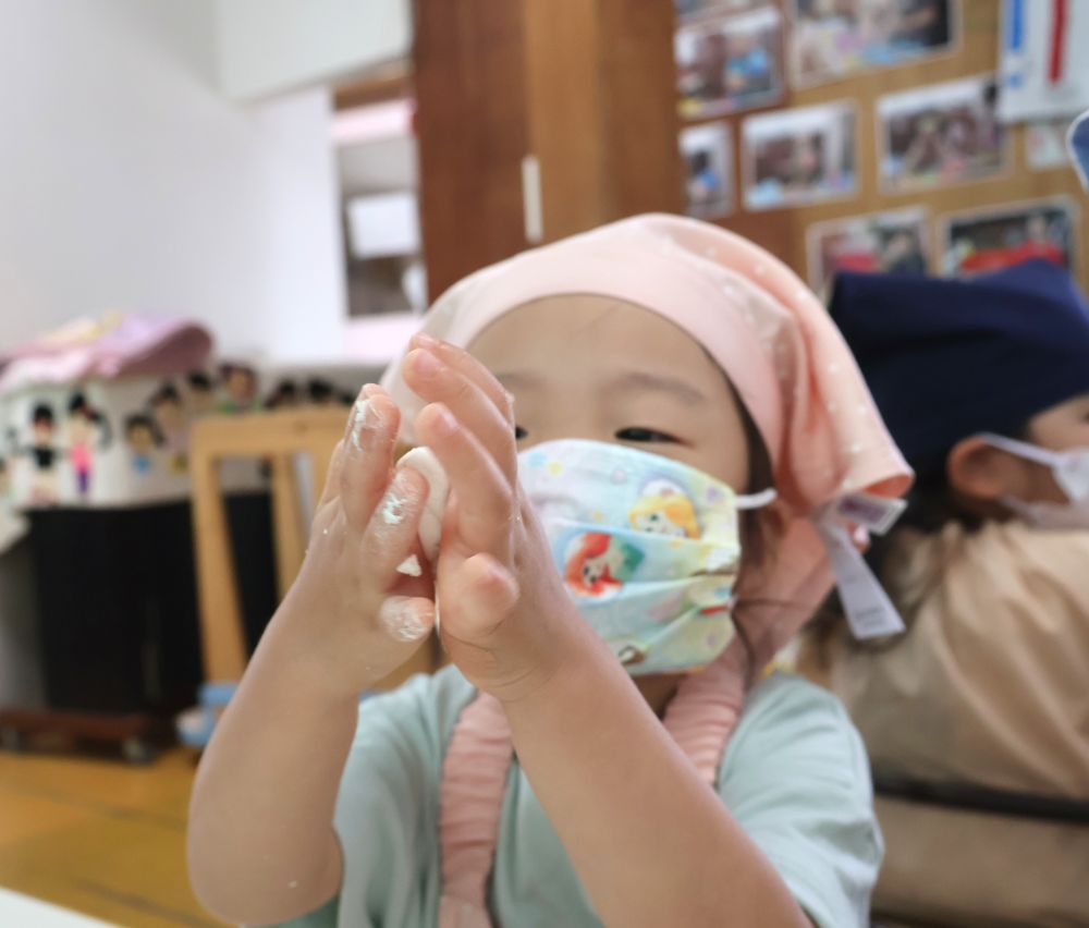 「ザラザラするーー」
「ちょっとかたいね」
「手にしろいのがついたー」
指先から感じる感触と、

「なんかご飯の匂いがするー」
白玉粉のほんのりと香るご飯の匂いを感じ、

目で見て感じ、耳で音を聞いて感じ、触って感じ、匂いで感じ・・・
あとは食べて味覚を感じる♡
まさに五感を使いながらのクッキング♡

生地がまとまったら一口大にして丸めます。
「せんせーこれであっとる？見てみて～」
上手に丸めたお団子を見せてくれました♡
粘土遊びでも泥団子でも上手にまんまるのお団子作りの上手なリス組さん今回もバッチリできました✨

あとは給食室で蒸してきな粉をまぶしたら出来上がりです♪
